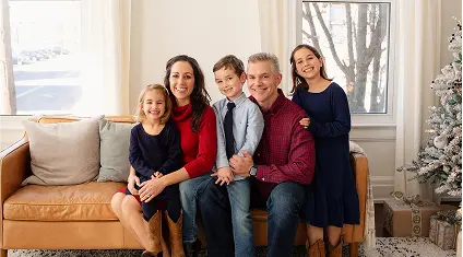 The Turner family sitting together on a couch near a Christmas tree.