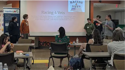 Group of students presenting a project titled “Racing 4 Vets” during a Magnified Giving event.